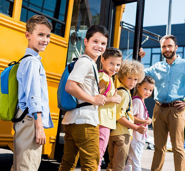 Happy children boarding a school bus
